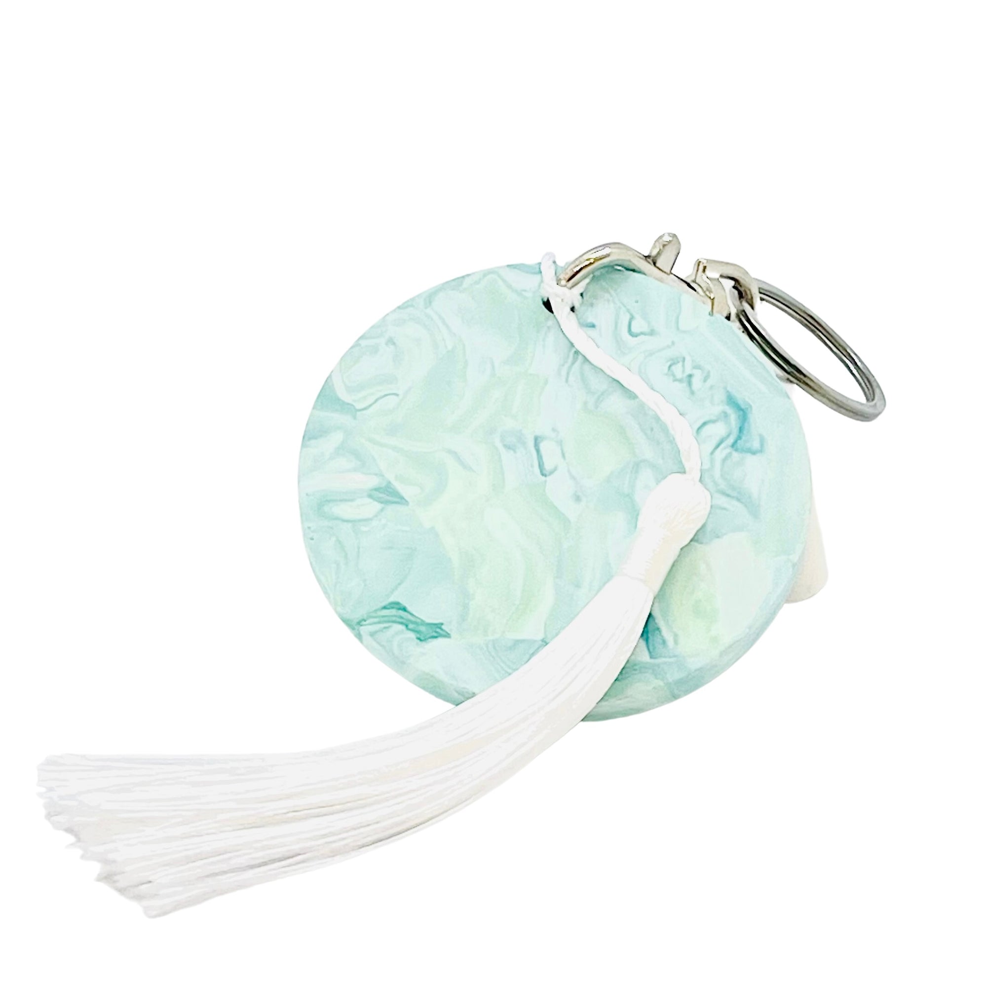 A round Jesmonite disc keyring measuring 6cm in diameter marbled with turquoise pigment.
