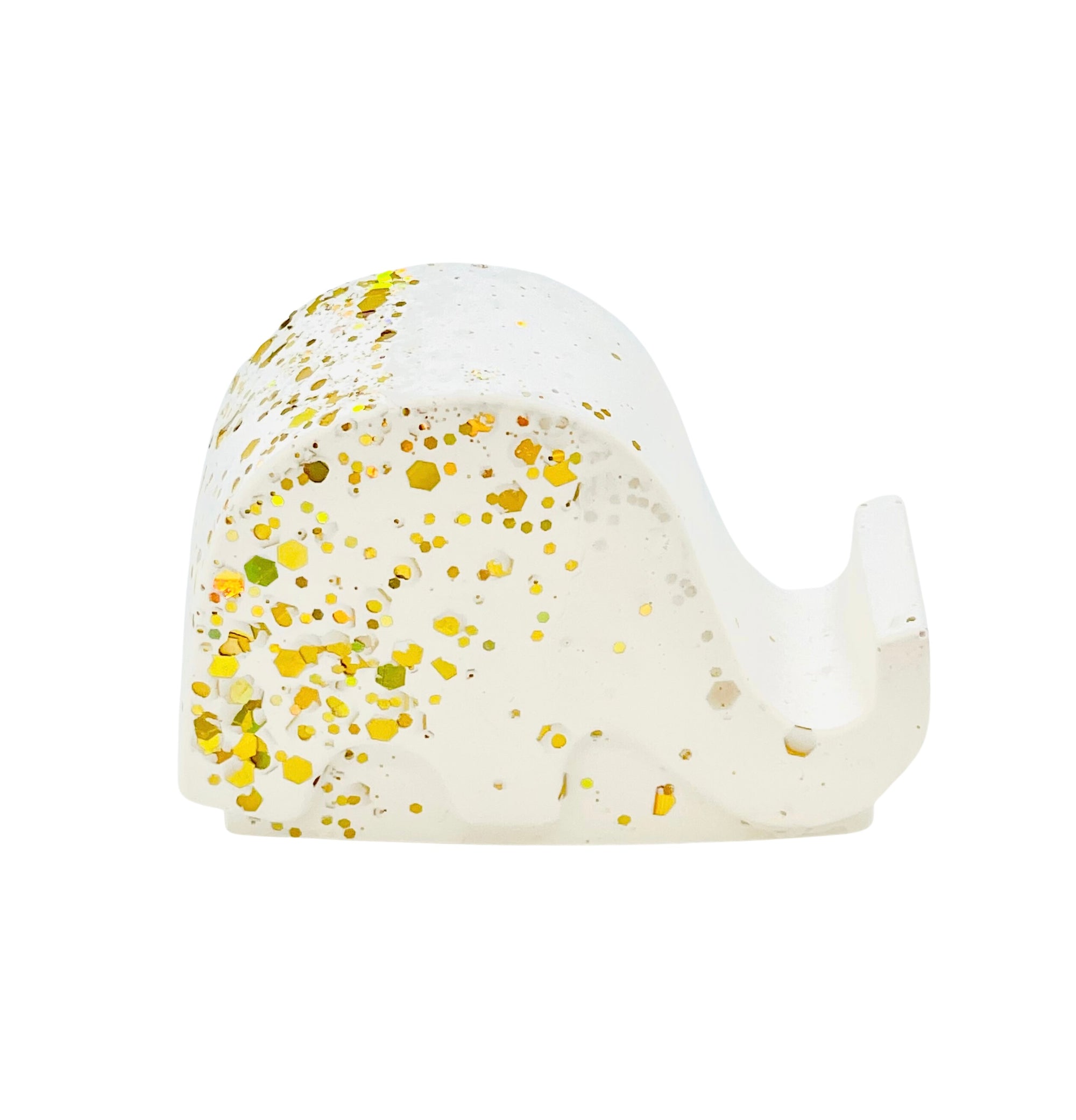 A white Jesmonite elephant mobile phone stand measuring 6.5cm in length sprinkled with gold glitter.