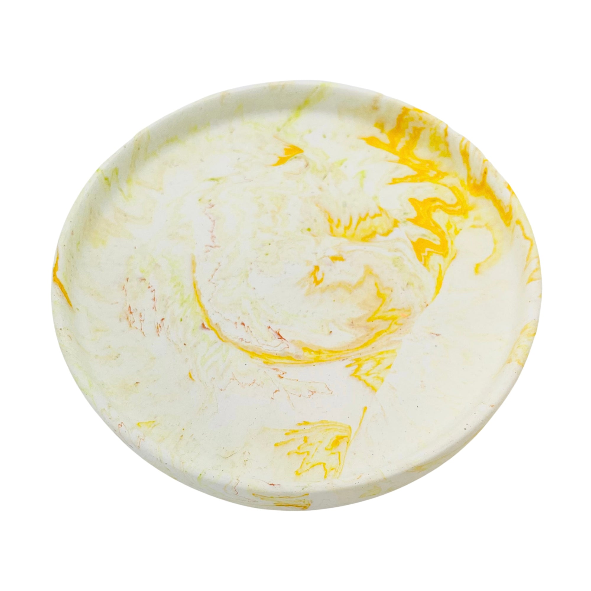 A circular Jesmonite trinket tray measuring 15.4cm in diameter marbled with yellow pigment.