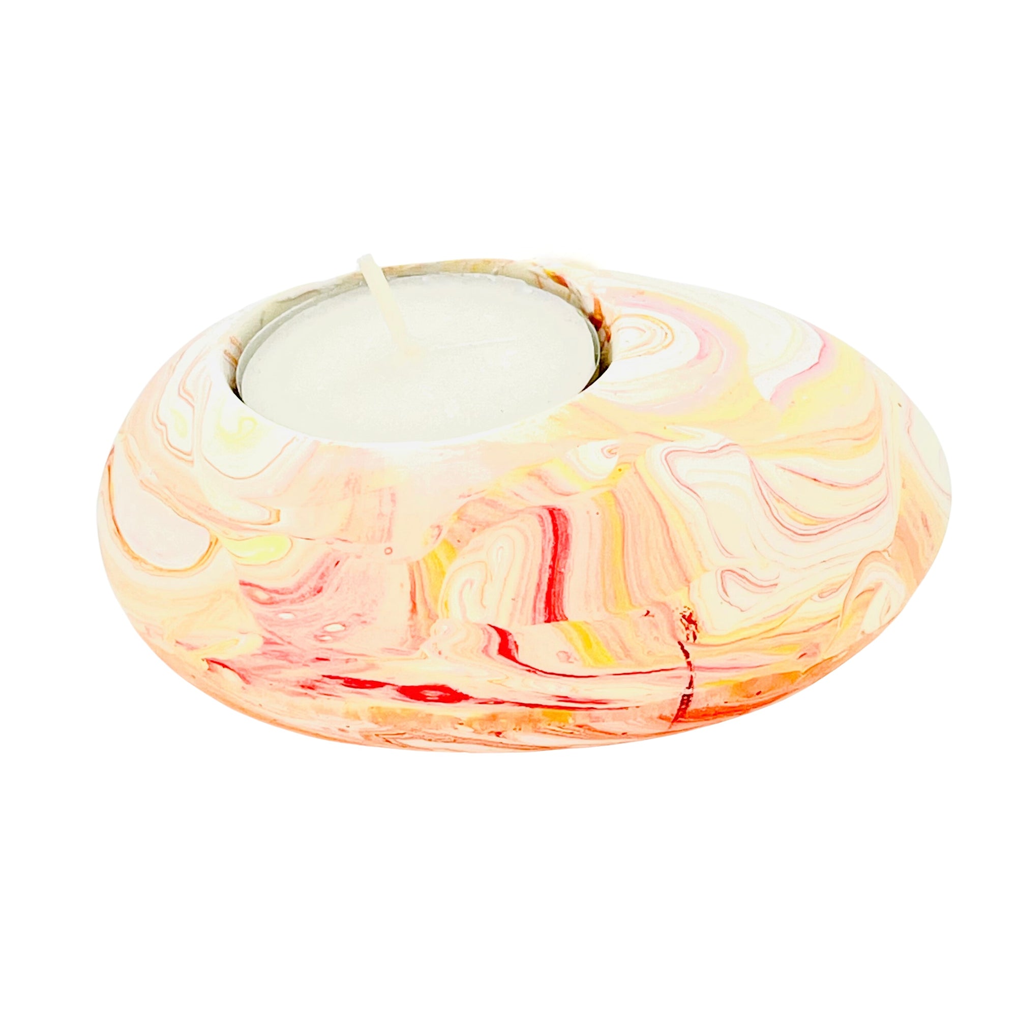 A Jesmonite tealight holder shaped like a pebble measuring 9cm in length and marbled with orange pigment.
