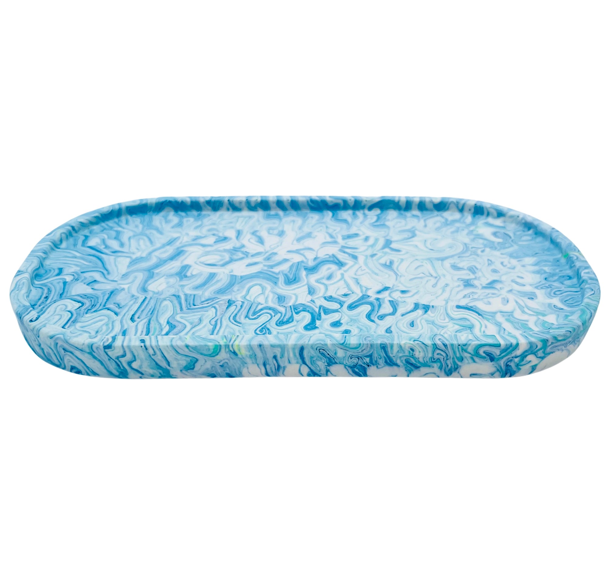 An oval Jesmonite trinket tray marbled with baby blue and turquoise pigment.