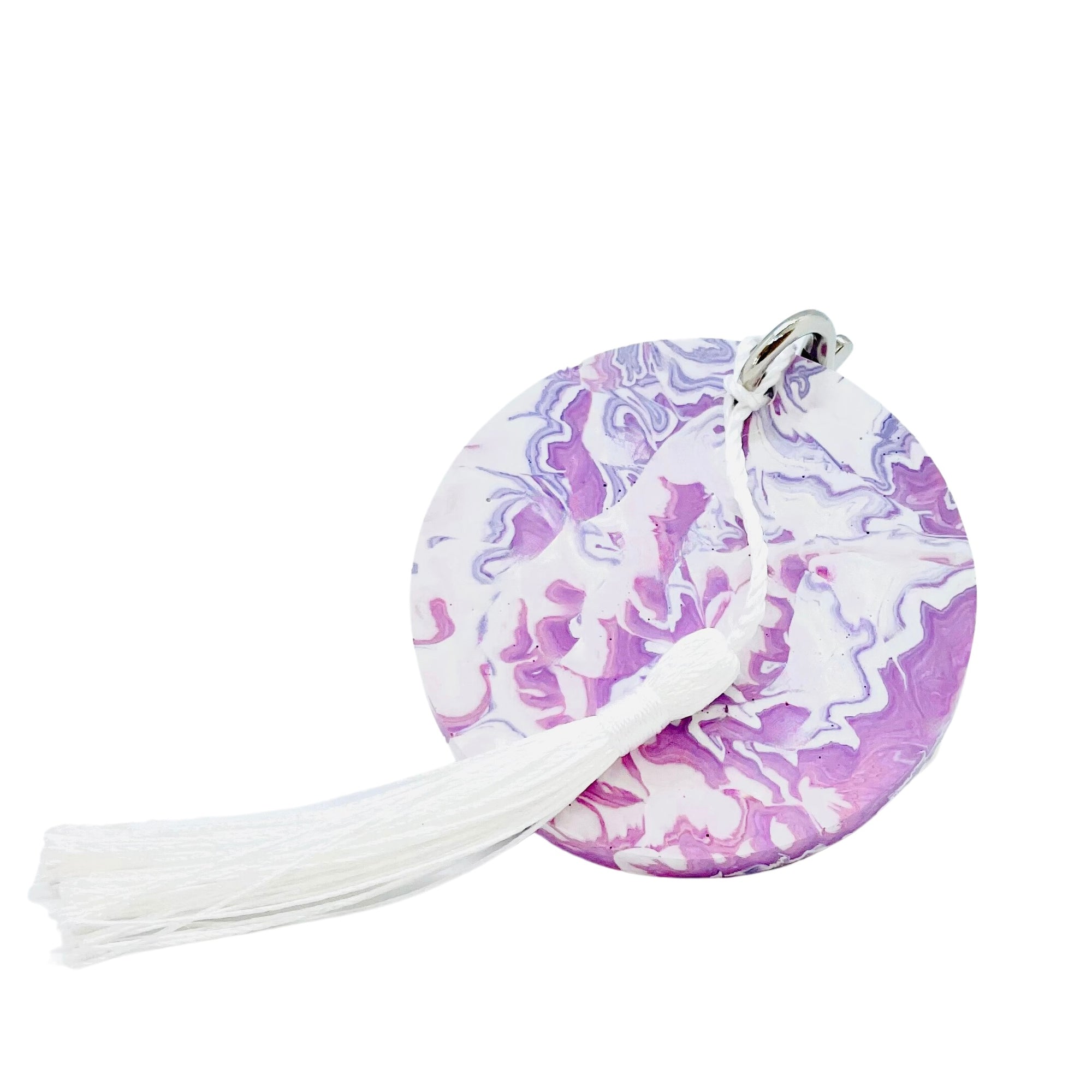 A round Jesmonite disc keyring measuring 6cm in diameter marbled with purple pigment.
