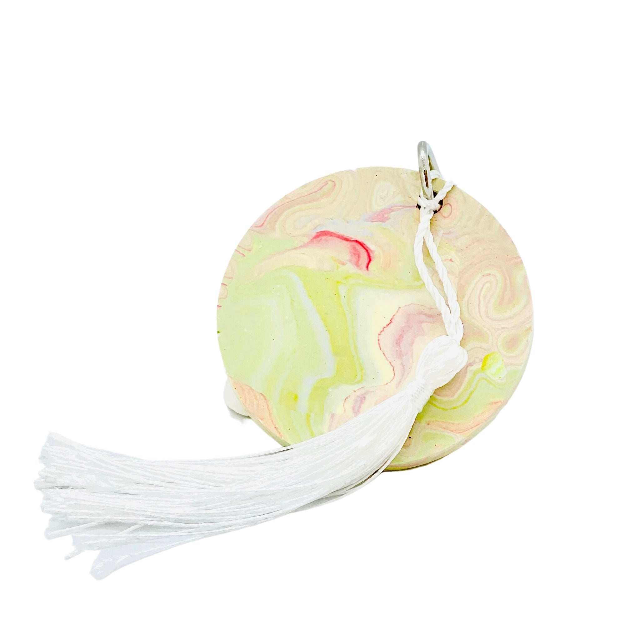 A round Jesmonite disc keyring measuring 6cm in diameter marbled with magenta and lime green pigment.
