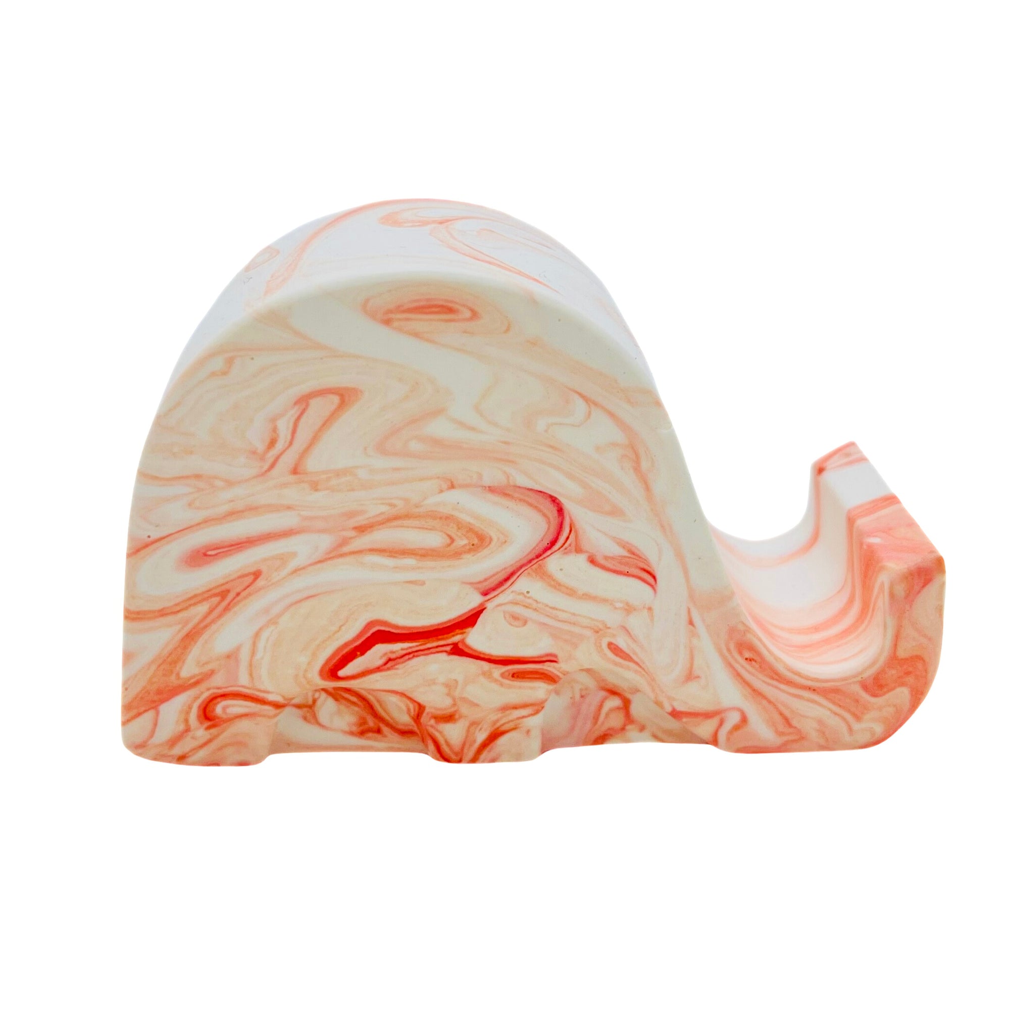 A Jesmonite elephant mobile phone stand measuring 6.5cm in length marbled with orange pigment.