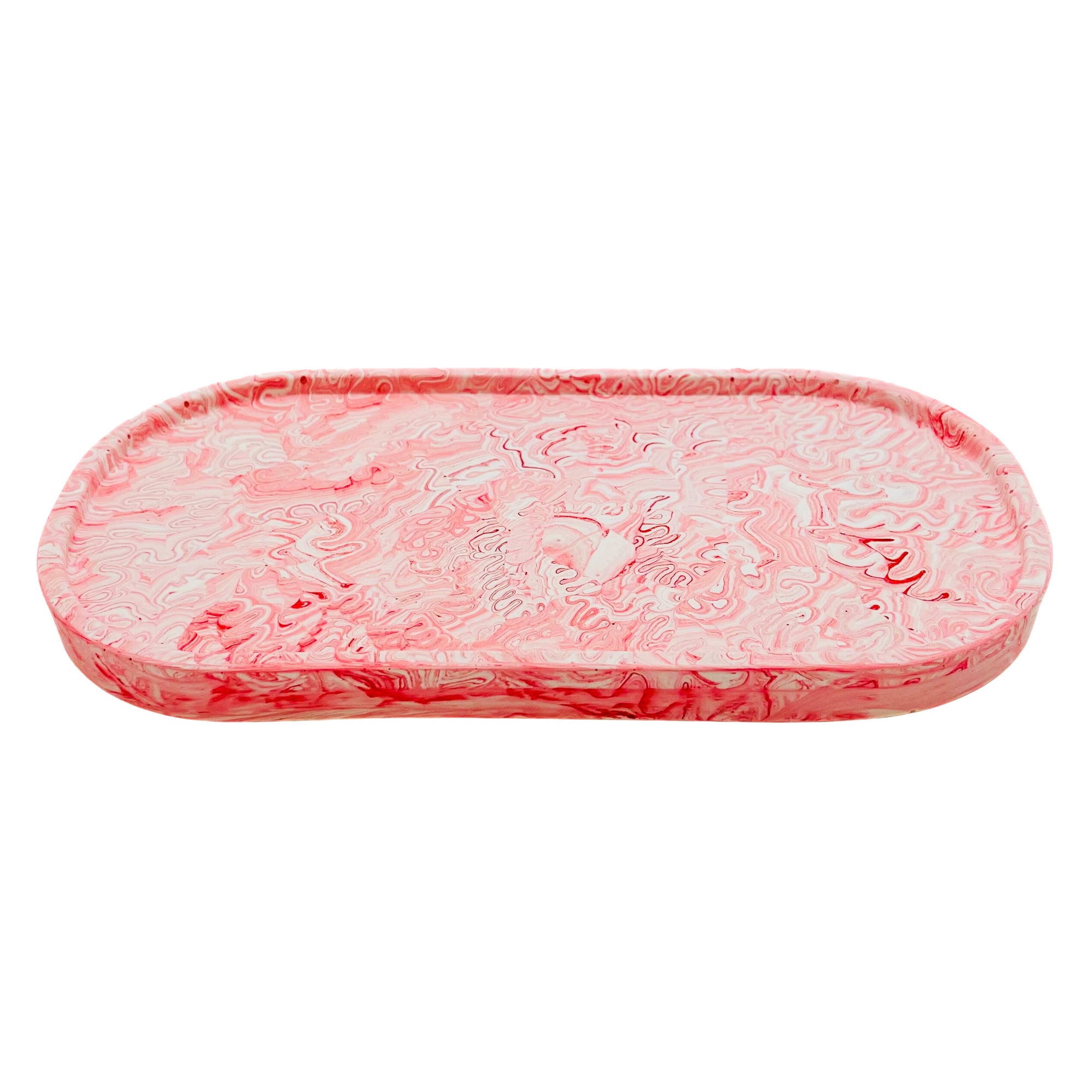 An oval Jesmonite trinket tray marbled with red pigment.