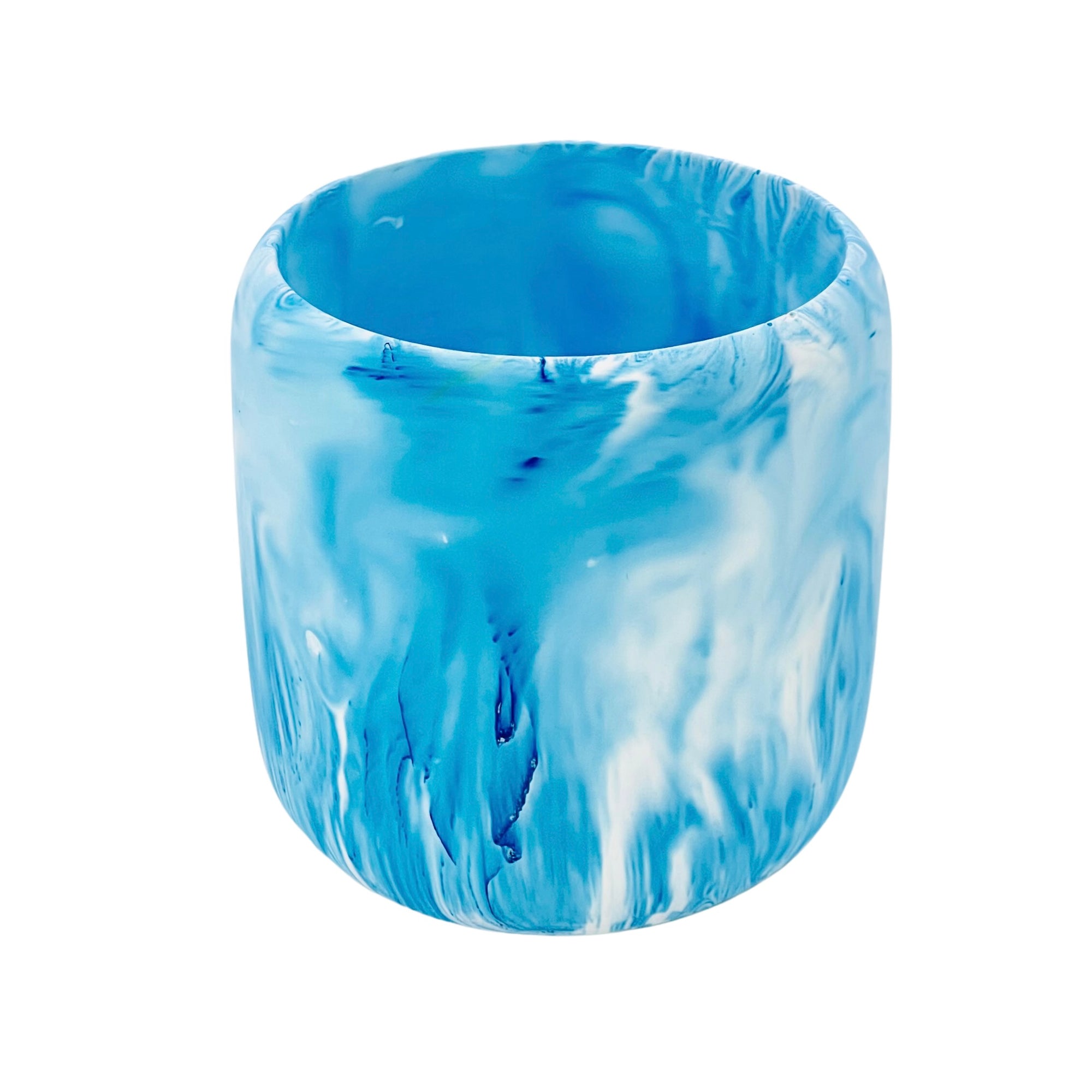 A Jesmonite tumbler with a 8.50cm diameter marbled with blue pigment.