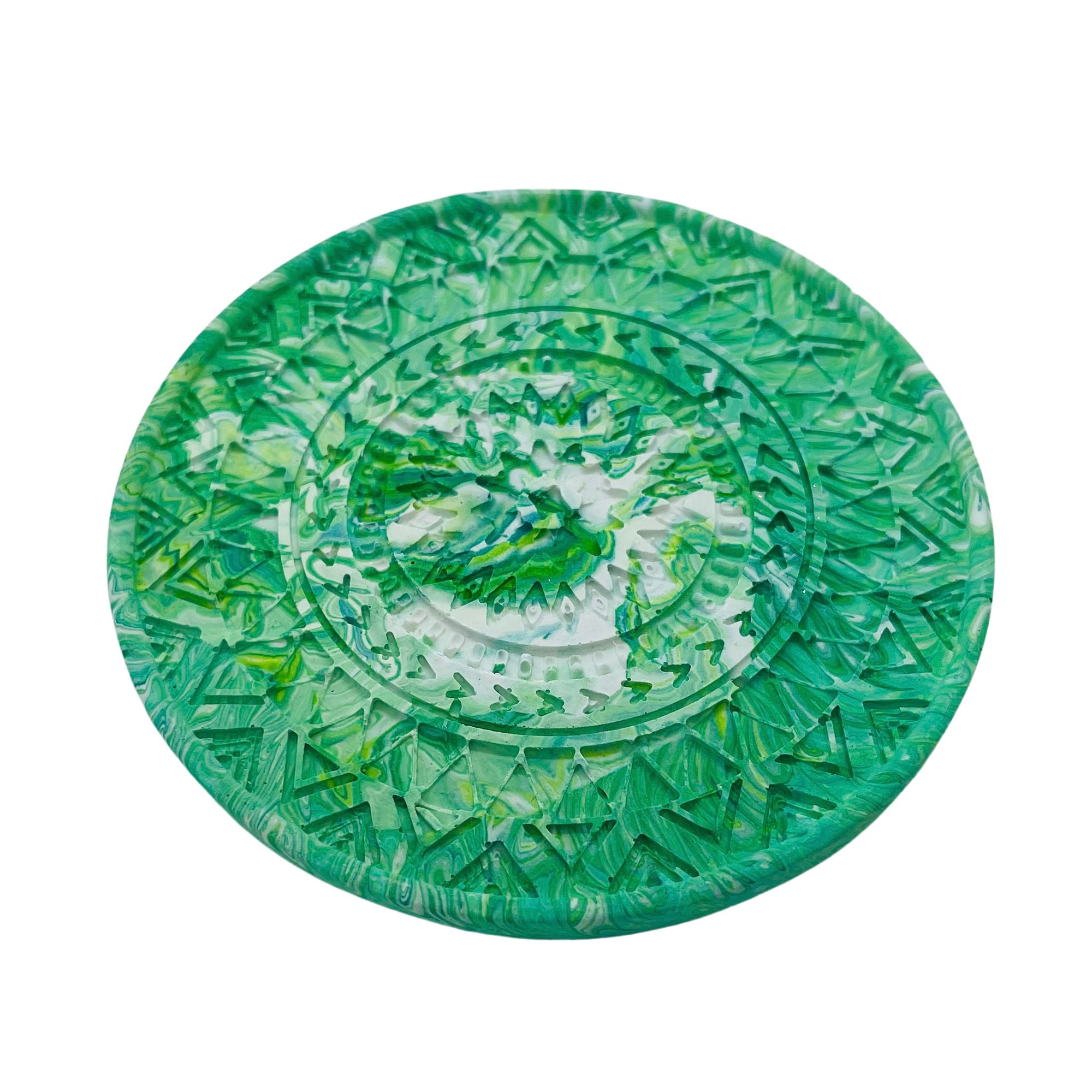 A circular mandela Jesmonite coaster measuring 9.3cm in diameter and 0.8 cm in height marbled with fern green pigment.
